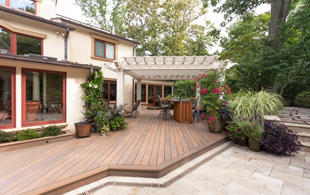 nice deck extending from the home to pergola and gardens